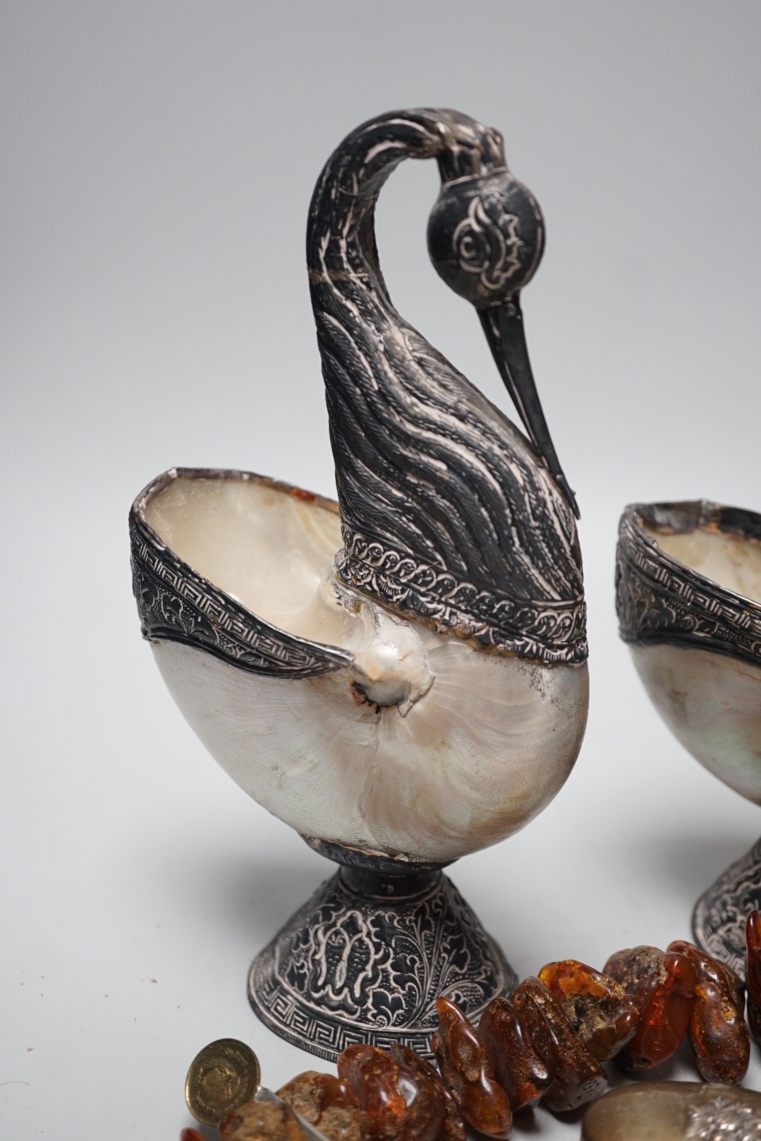 A pair of mother of pearl and silvered swan ornaments, amber and mixed collectables